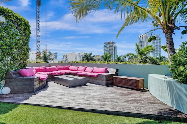 wooden deck featuring an outdoor living space with a fire pit