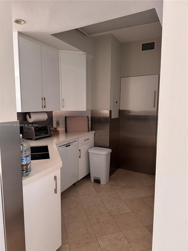 kitchen with dishwasher, white cabinetry, and light tile patterned flooring