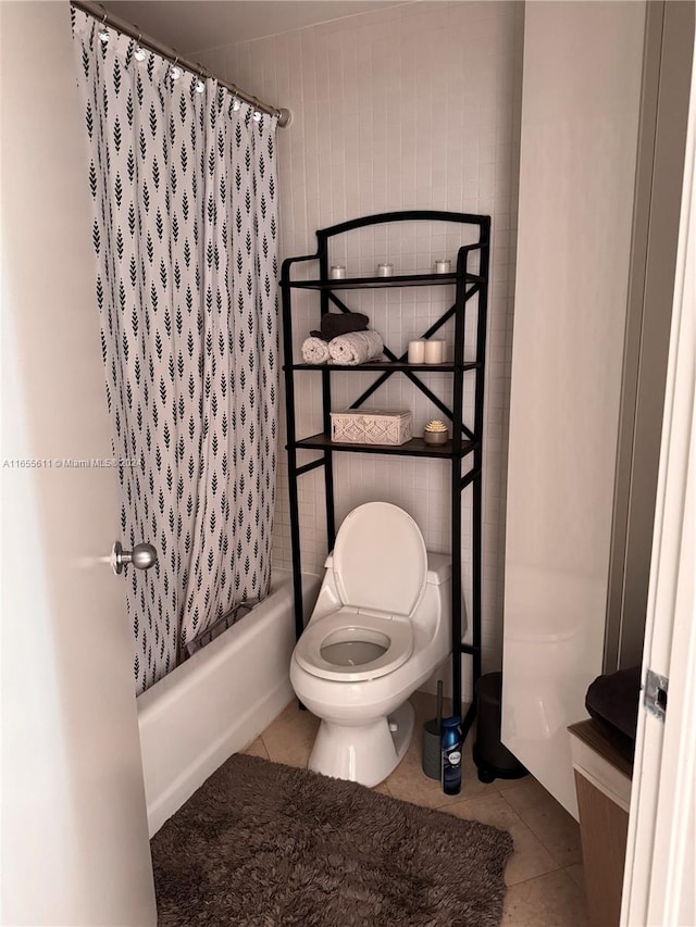 bathroom with shower / bath combo with shower curtain, toilet, and tile patterned floors