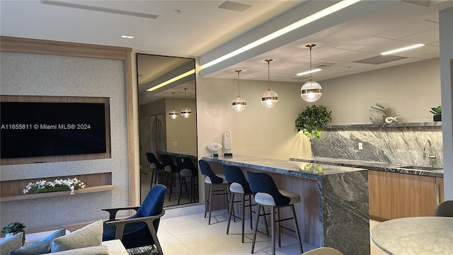 bar featuring dark stone countertops and sink