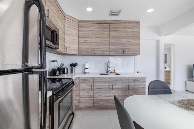 kitchen with stainless steel appliances, sink, and decorative backsplash