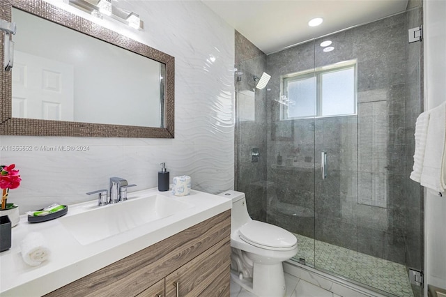 bathroom with tile walls, toilet, a shower with door, and vanity