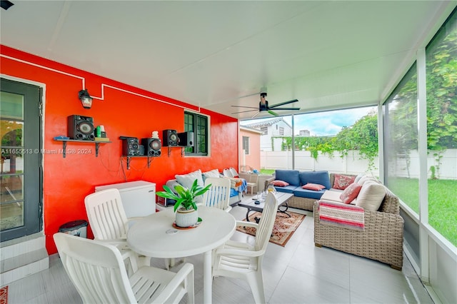 sunroom / solarium featuring a healthy amount of sunlight and ceiling fan