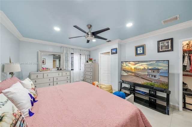 bedroom featuring a walk in closet, a closet, ornamental molding, ceiling fan, and light tile patterned flooring