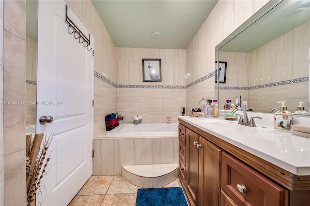 bathroom featuring tile patterned floors, tile walls, a bathtub, and vanity