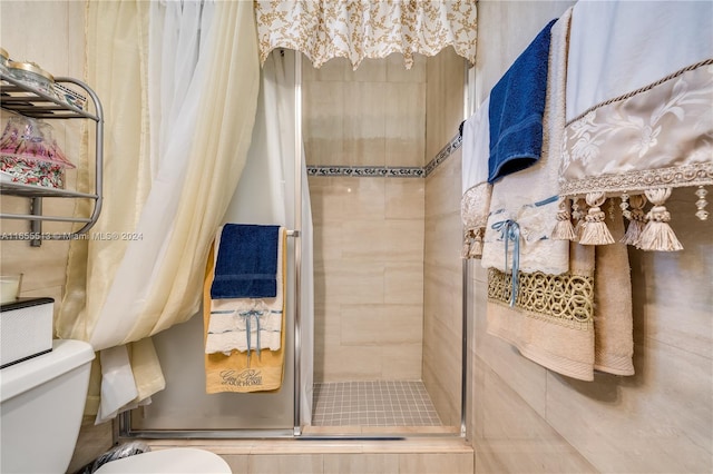 bathroom featuring toilet and curtained shower