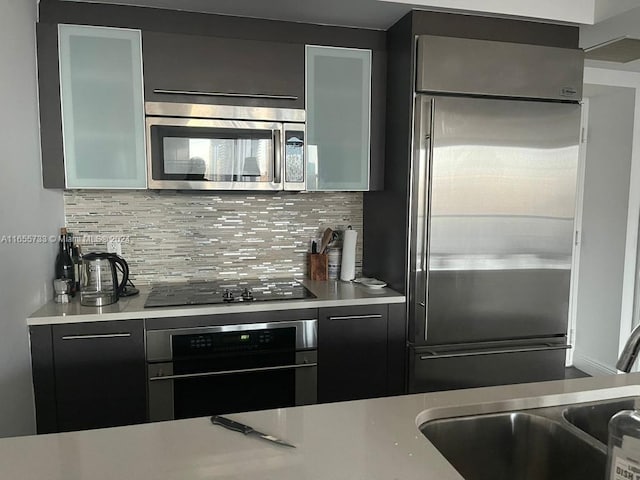 kitchen featuring sink, appliances with stainless steel finishes, and decorative backsplash