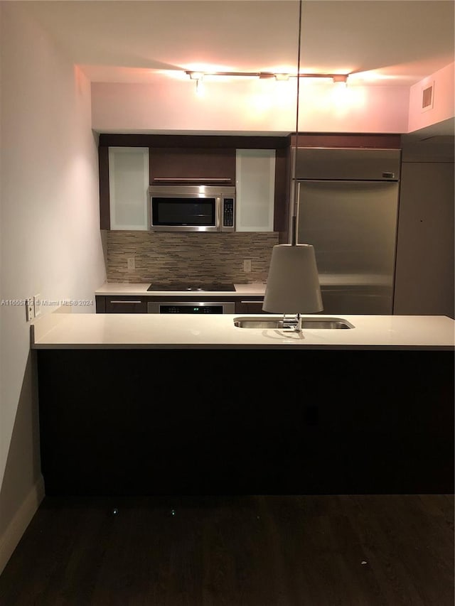 kitchen featuring dark hardwood / wood-style flooring, stainless steel appliances, and tasteful backsplash