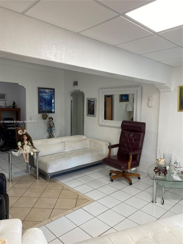 tiled living room featuring a paneled ceiling