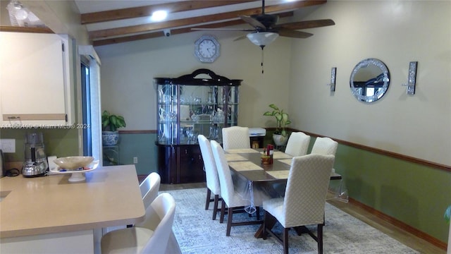 dining space featuring ceiling fan and vaulted ceiling with beams