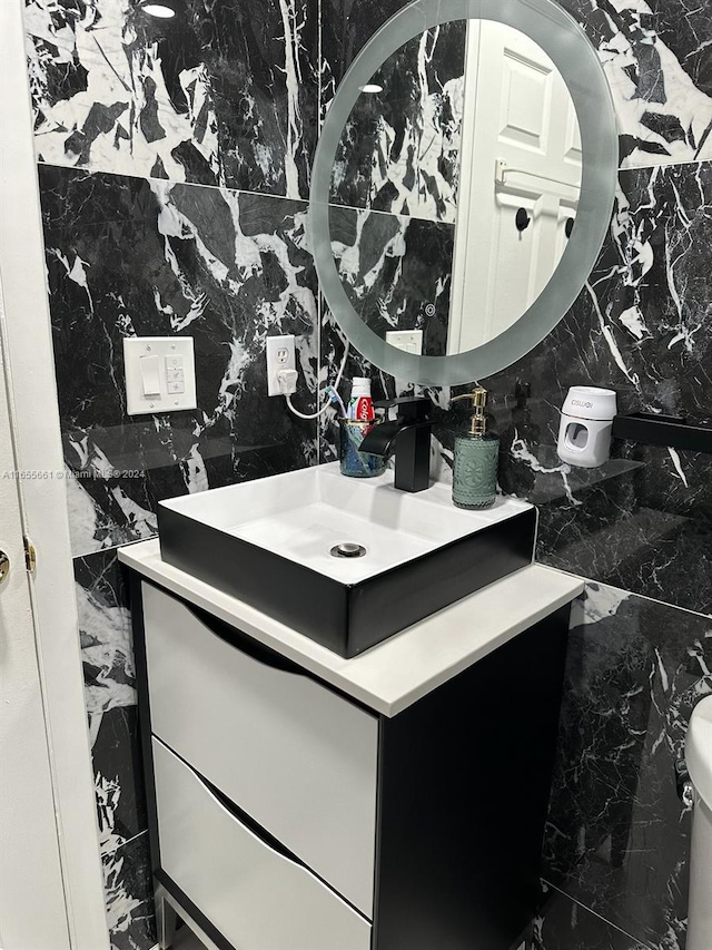 bathroom featuring vanity, toilet, and tile walls