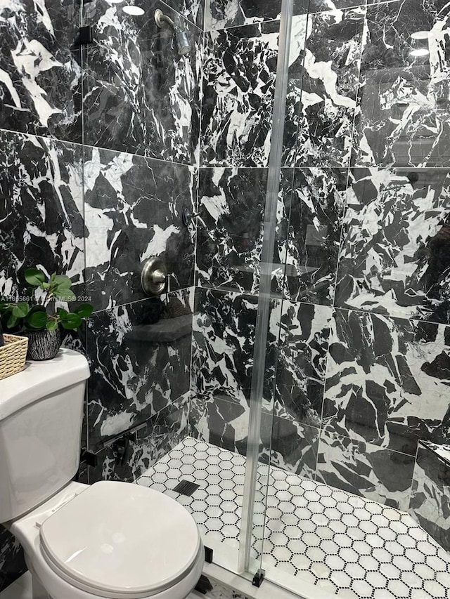 bathroom featuring tiled shower and toilet