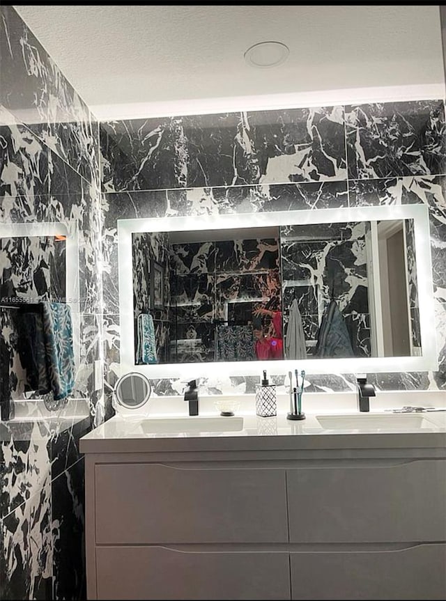 bathroom featuring vanity, tile walls, and a textured ceiling