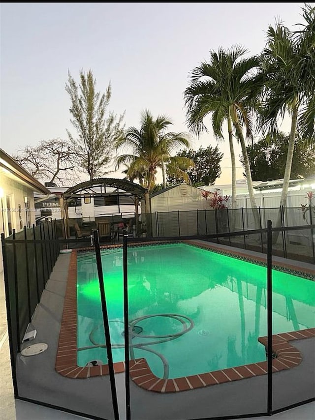 pool at dusk featuring a gazebo