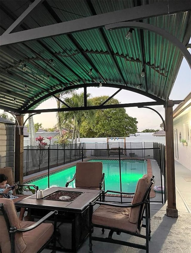 view of swimming pool featuring a fire pit and a patio area