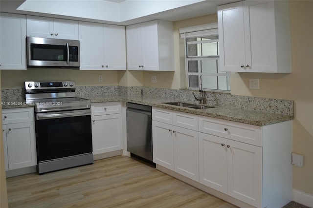 kitchen with sink, appliances with stainless steel finishes, and white cabinetry