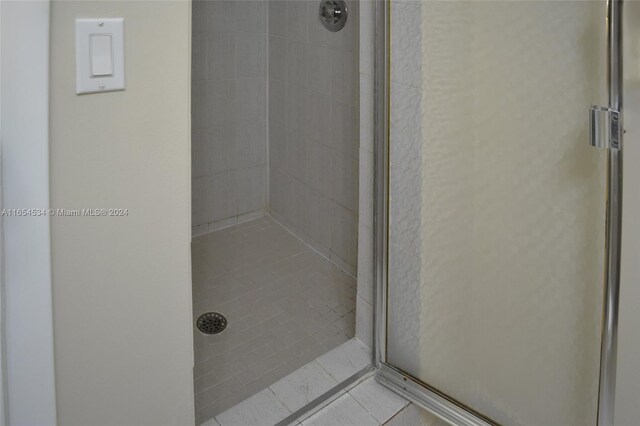 bathroom with tile patterned flooring and a shower with door