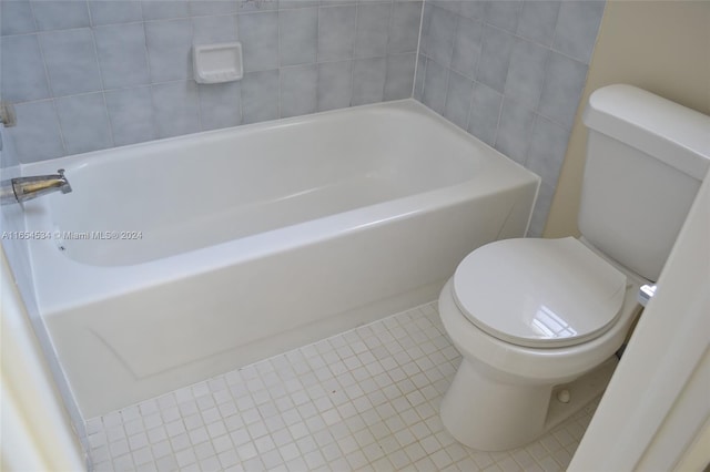 bathroom with toilet, a bathing tub, and tile patterned floors