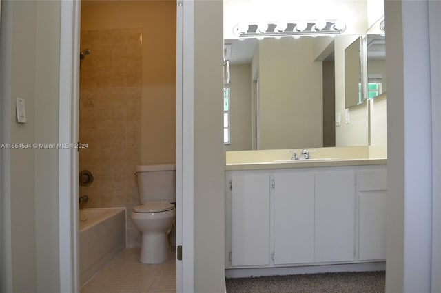 full bathroom featuring tile patterned floors, tiled shower / bath, toilet, and vanity