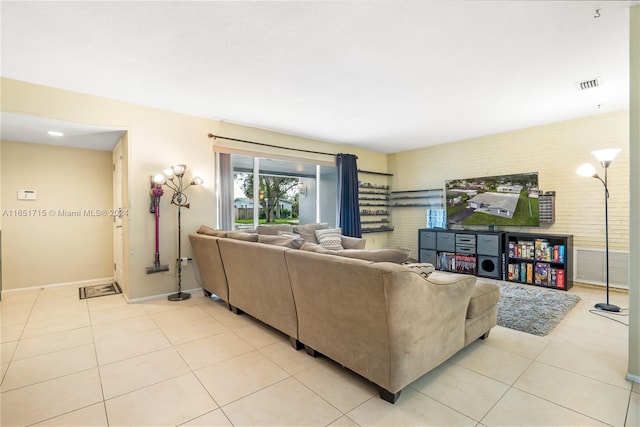 living room with brick wall and light tile patterned floors