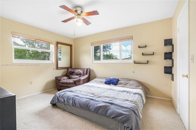 carpeted bedroom with multiple windows and ceiling fan