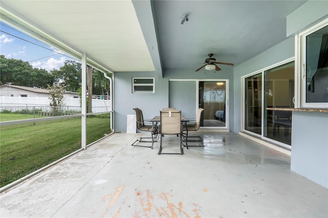 unfurnished sunroom with ceiling fan