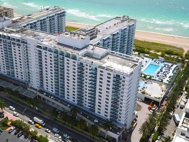 drone / aerial view featuring a beach view and a water view