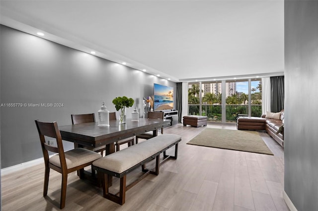 dining room featuring floor to ceiling windows and light hardwood / wood-style floors