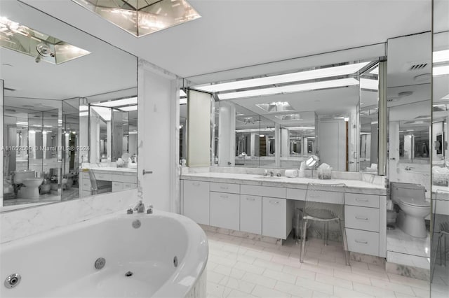 bathroom with tile patterned flooring, vanity, toilet, and a bath