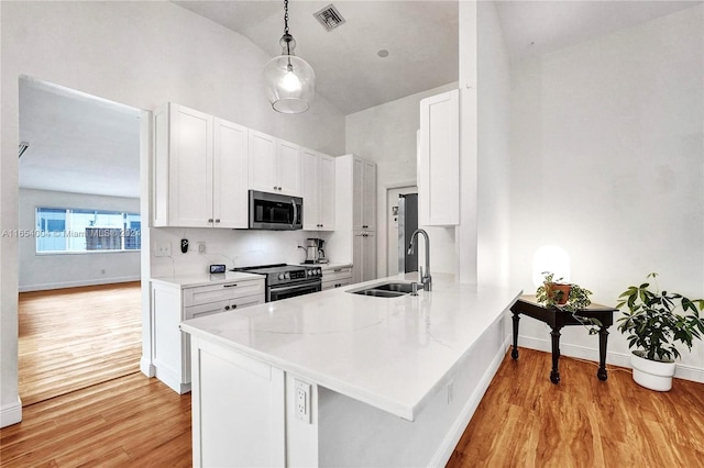 kitchen with sink, stainless steel appliances, kitchen peninsula, white cabinets, and light wood-type flooring