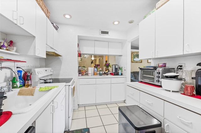 kitchen featuring white cabinets, white range with electric stovetop, light tile patterned floors, and sink