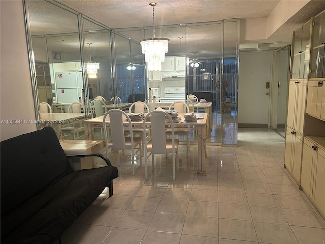 dining room featuring tile patterned flooring, ceiling fan with notable chandelier, and a textured ceiling