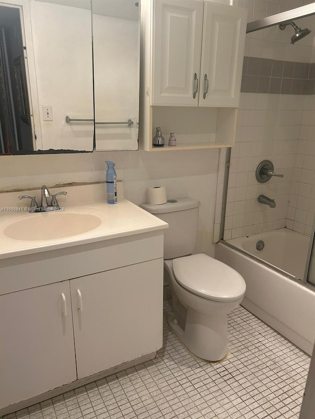 full bathroom with tile patterned floors, toilet, tiled shower / bath combo, and vanity