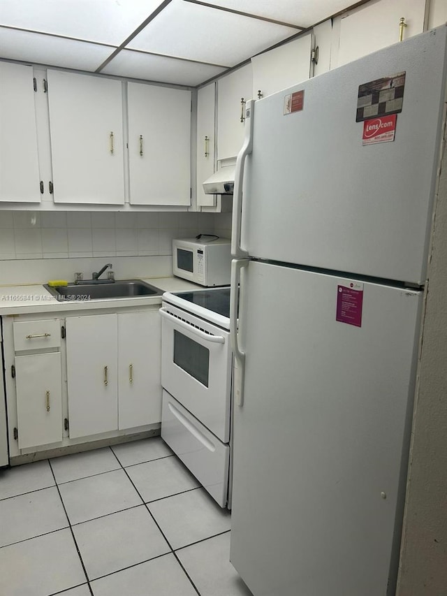 kitchen with white cabinetry, light tile patterned floors, white appliances, and sink