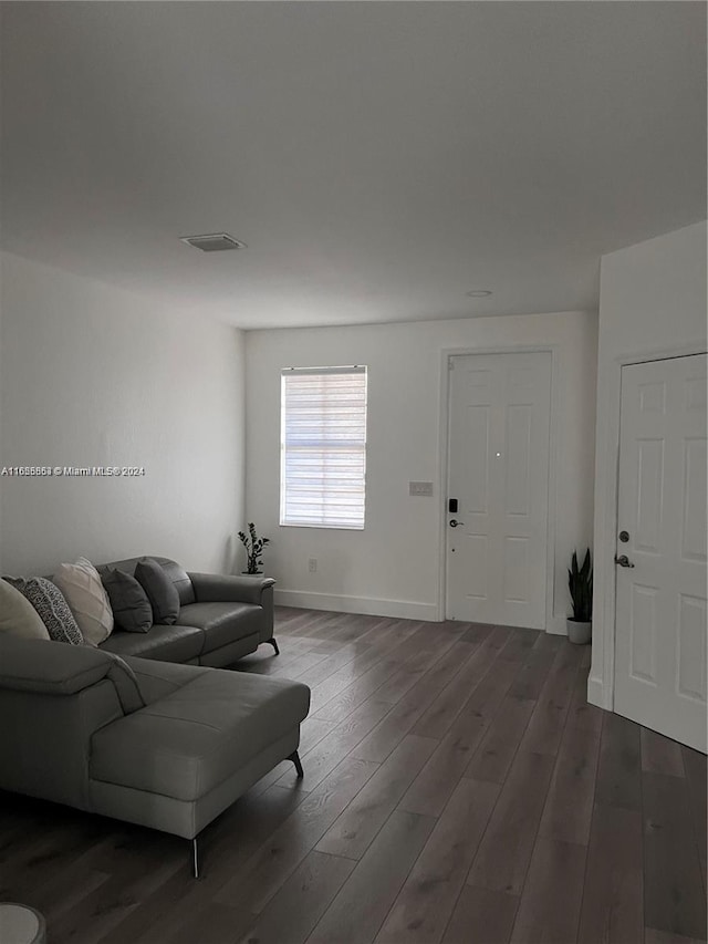 living room featuring visible vents, baseboards, and wood finished floors