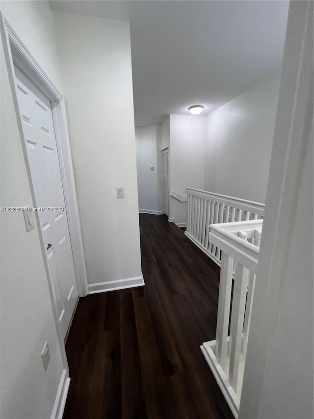 hallway with wood finished floors and baseboards