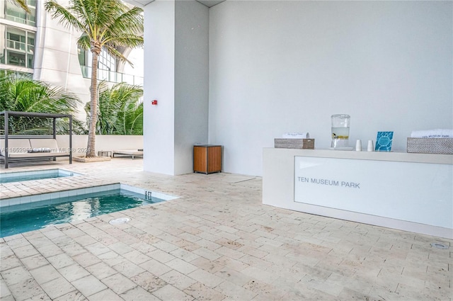 view of swimming pool featuring a patio and an in ground hot tub