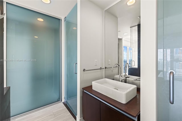 bathroom with hardwood / wood-style flooring, vanity, and an enclosed shower