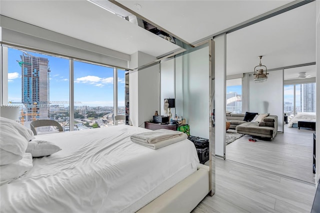 bedroom featuring floor to ceiling windows and light wood-type flooring