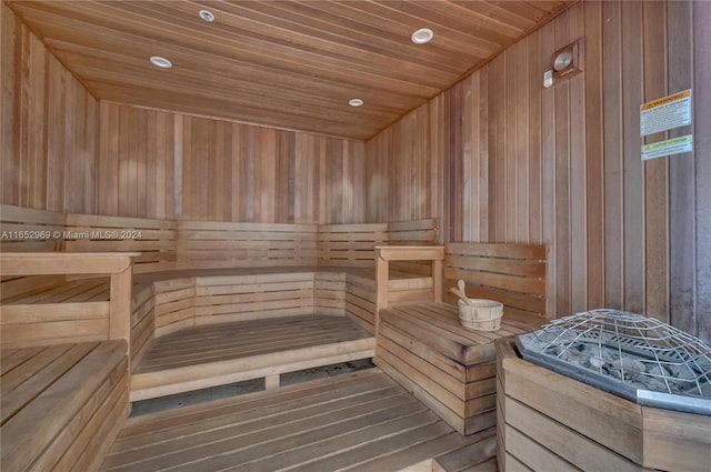 view of sauna / steam room with wood ceiling, wooden walls, and hardwood / wood-style flooring