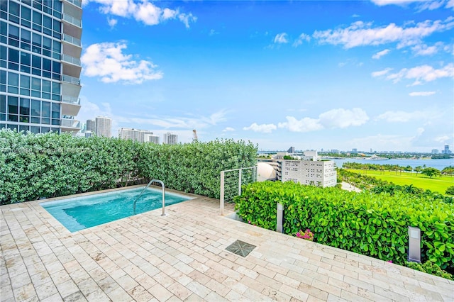 view of swimming pool with a patio and a water view