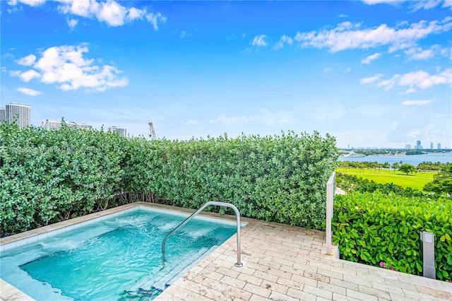 view of swimming pool with a patio and a water view