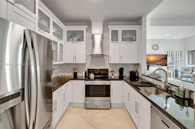 kitchen featuring stainless steel appliances, sink, decorative backsplash, white cabinets, and wall chimney range hood