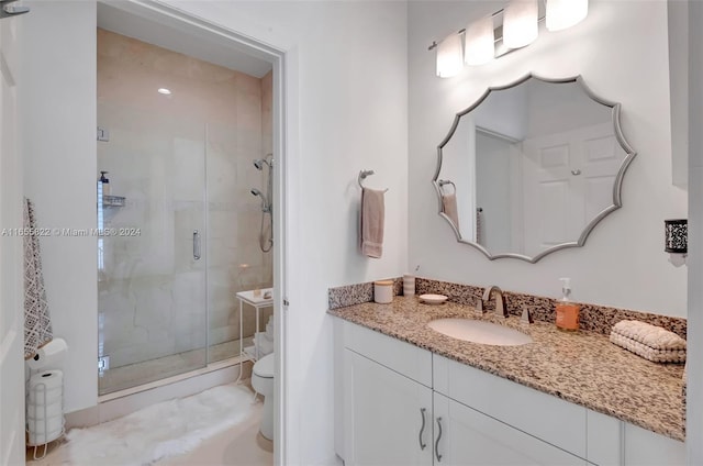 bathroom featuring walk in shower, toilet, and vanity