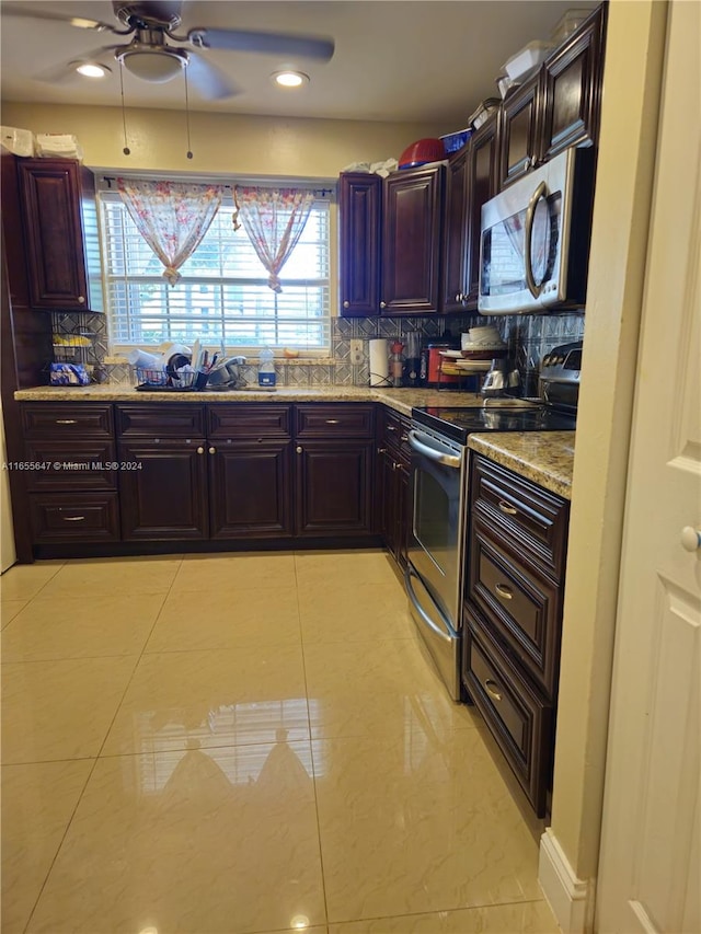 kitchen featuring light tile patterned floors, light stone countertops, stainless steel appliances, ceiling fan, and decorative backsplash