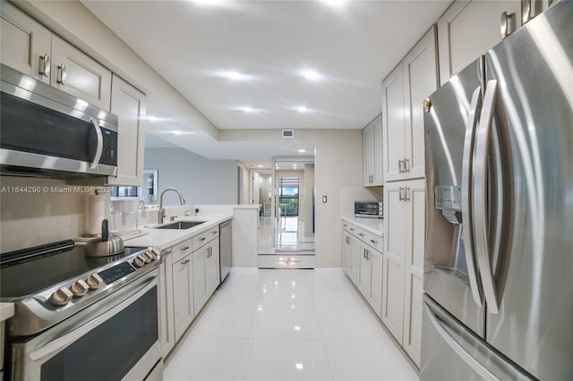 kitchen featuring appliances with stainless steel finishes, light tile patterned floors, and sink