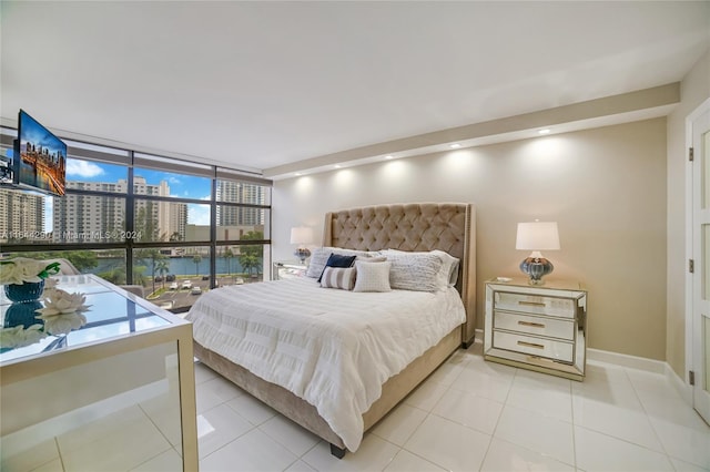 bedroom featuring light tile patterned floors and a wall of windows