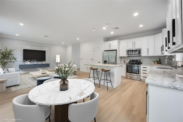 dining space with recessed lighting, visible vents, crown molding, and light wood finished floors