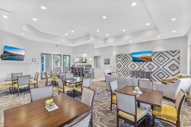 dining space with a raised ceiling, crown molding, recessed lighting, and visible vents