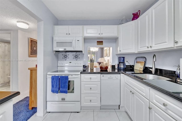 kitchen featuring a textured ceiling, sink, white appliances, and white cabinetry